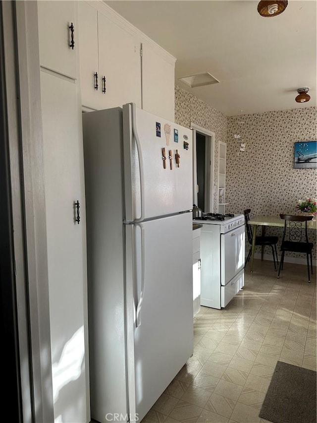 kitchen featuring white cabinetry and white appliances