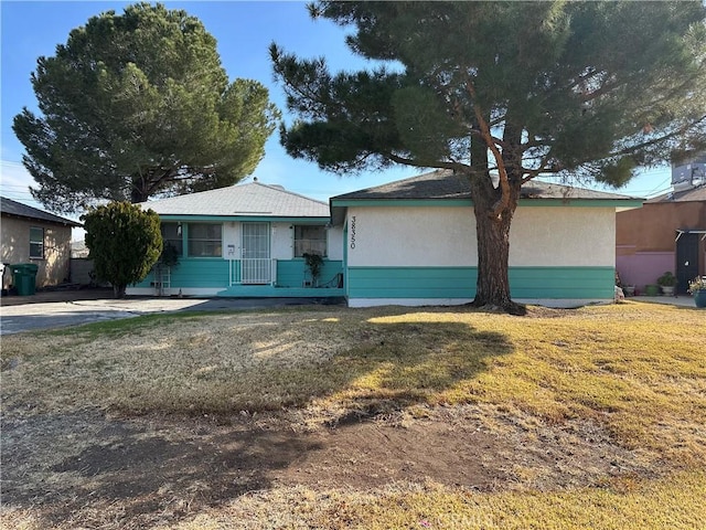 single story home featuring a front lawn