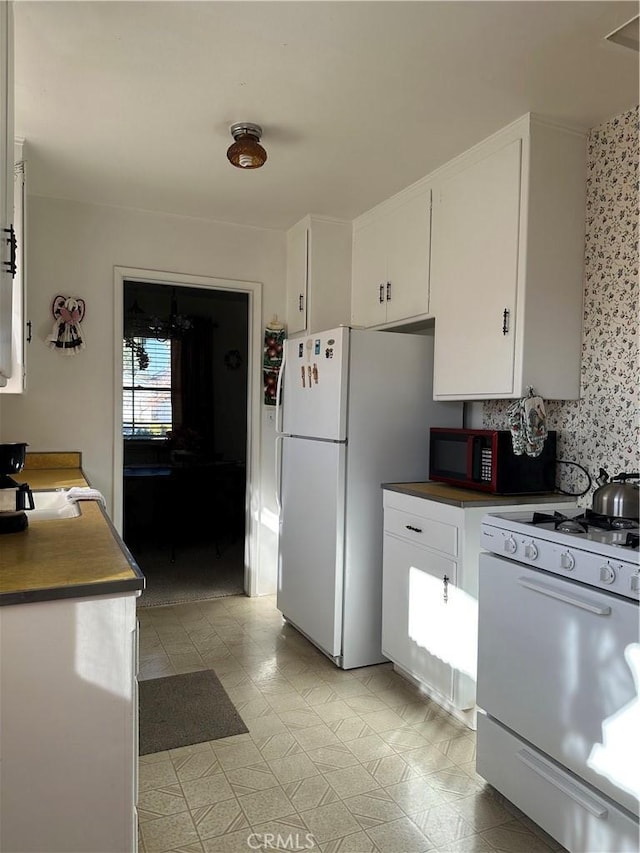 kitchen with white appliances and white cabinets