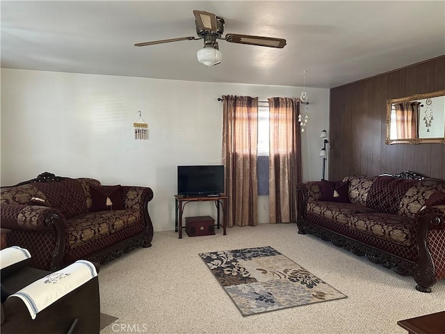 living room with ceiling fan, light colored carpet, and wooden walls