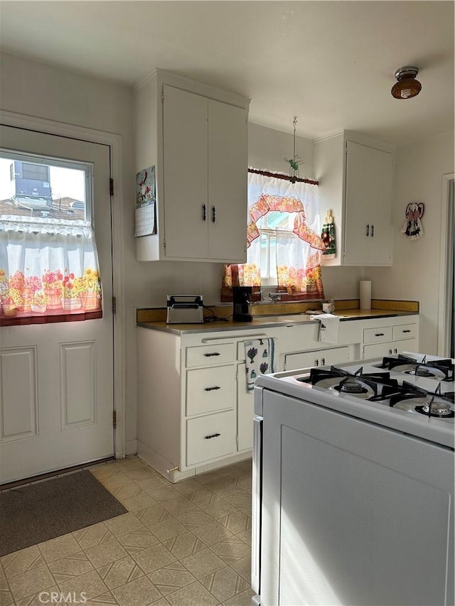 kitchen with white cabinetry and white range with gas cooktop