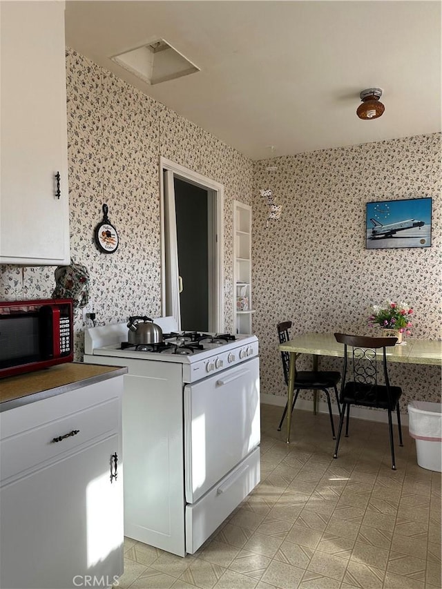 kitchen featuring white cabinets and gas range gas stove