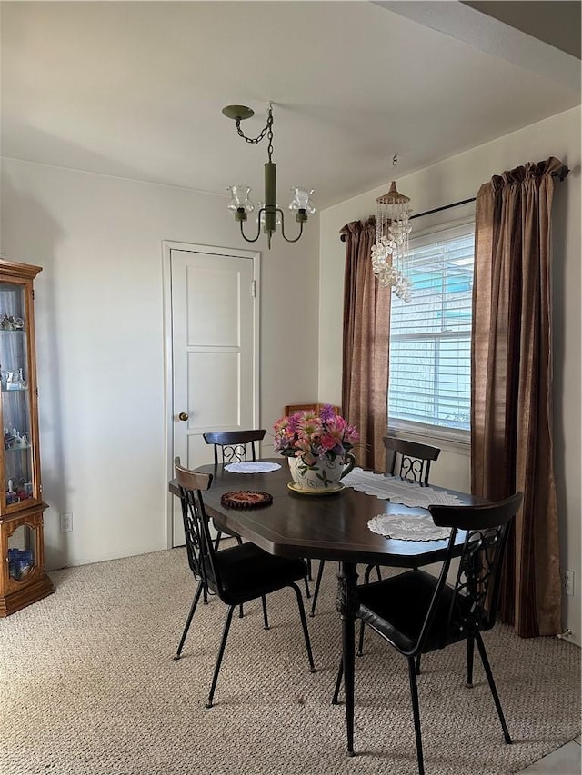 carpeted dining area with a notable chandelier