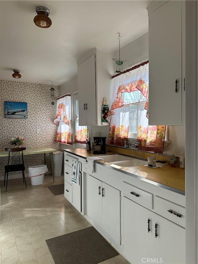 kitchen featuring sink and white cabinets