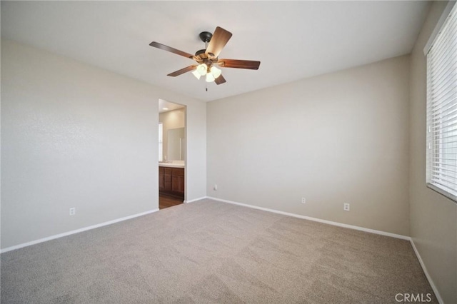 unfurnished bedroom featuring ceiling fan, connected bathroom, and dark carpet