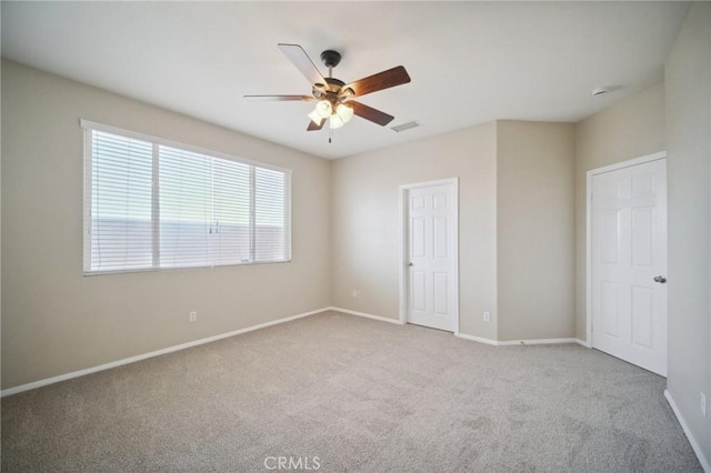 unfurnished bedroom featuring light carpet and ceiling fan