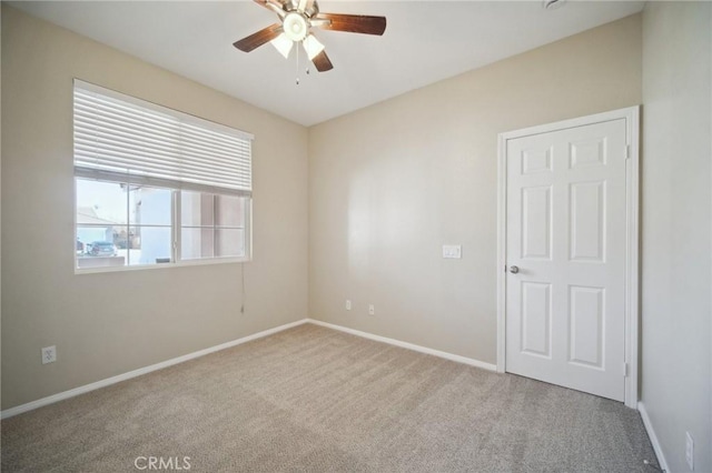 empty room featuring carpet floors and ceiling fan