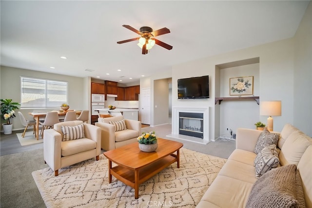 carpeted living room featuring ceiling fan