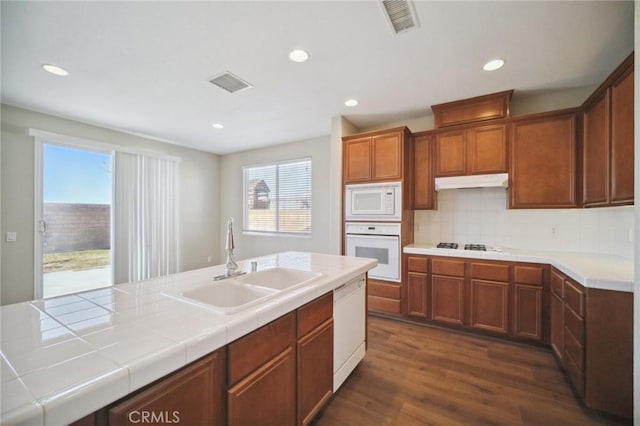 kitchen featuring white appliances, a healthy amount of sunlight, tile countertops, and sink