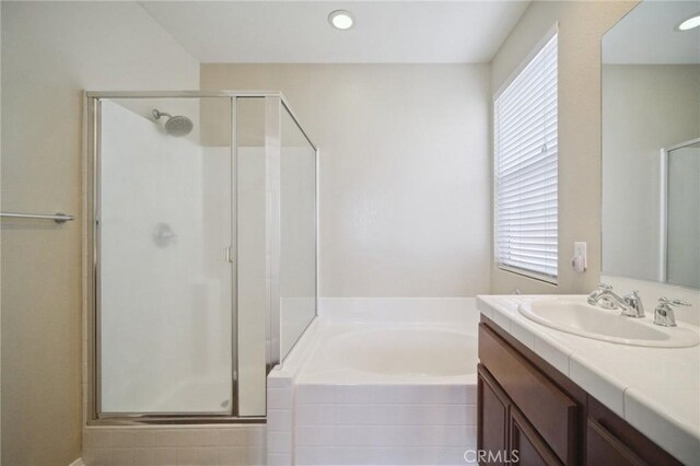 bathroom with shower with separate bathtub and vanity