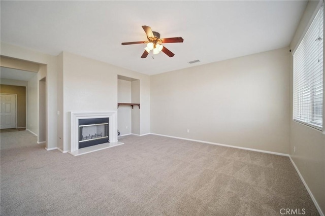 unfurnished living room with light colored carpet and ceiling fan