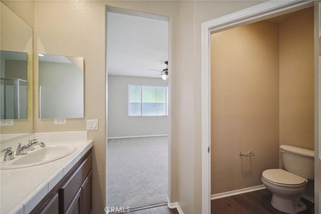 bathroom featuring ceiling fan, vanity, toilet, and wood-type flooring