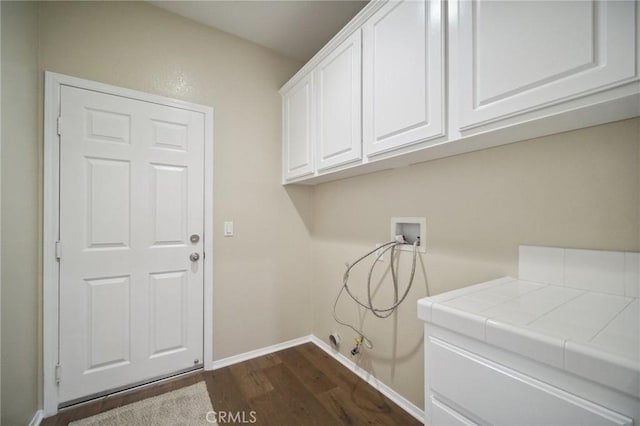 clothes washing area with washer hookup, hookup for a gas dryer, dark hardwood / wood-style floors, and cabinets