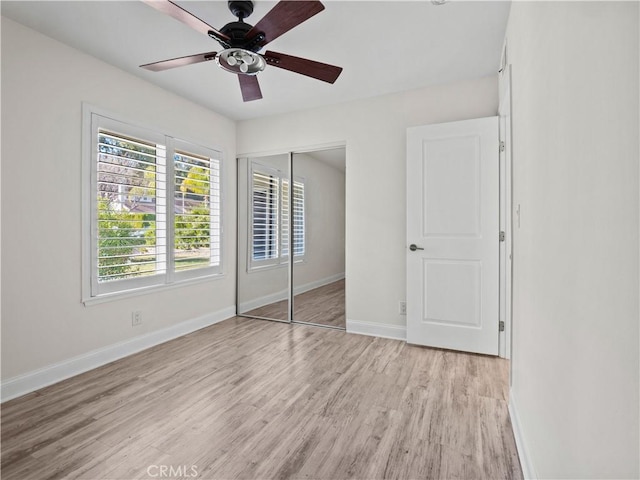 unfurnished bedroom featuring a closet, ceiling fan, and light wood-type flooring