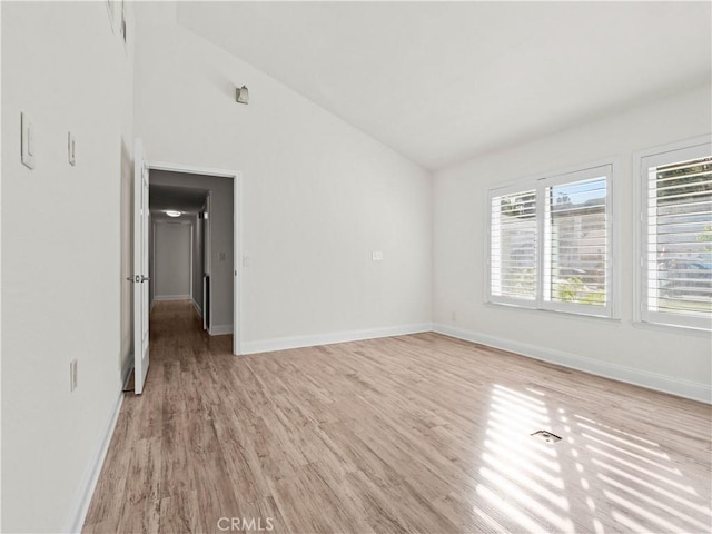 unfurnished room with high vaulted ceiling and light wood-type flooring