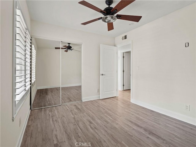 unfurnished bedroom with hardwood / wood-style flooring, a closet, and ceiling fan