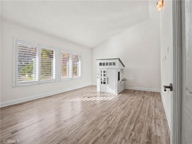 interior space featuring lofted ceiling and light hardwood / wood-style floors