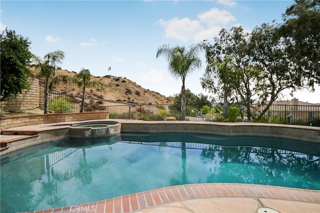 view of swimming pool with an in ground hot tub and a mountain view