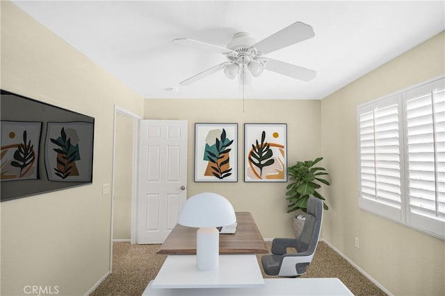 carpeted office featuring ceiling fan