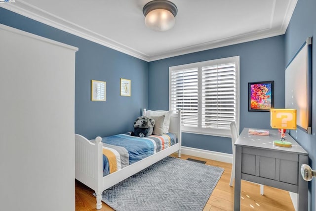 bedroom with hardwood / wood-style flooring and ornamental molding