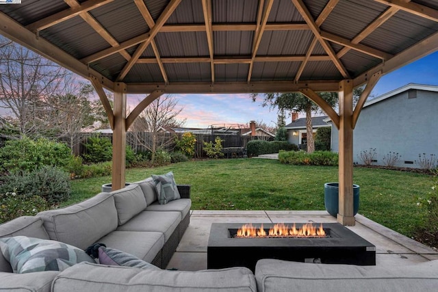 patio terrace at dusk with a yard, a gazebo, and an outdoor living space with a fire pit