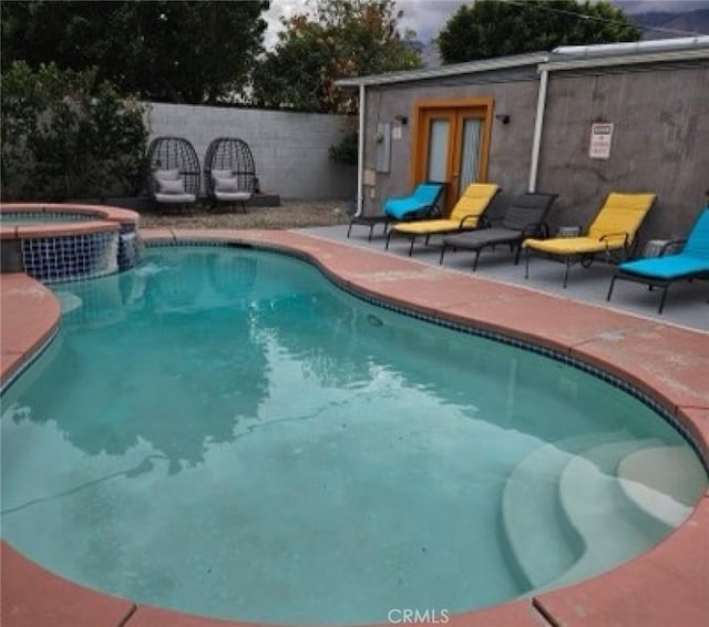 view of swimming pool with an in ground hot tub and a patio