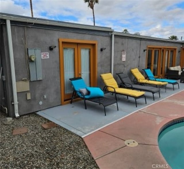 back of house with a pool and a patio area