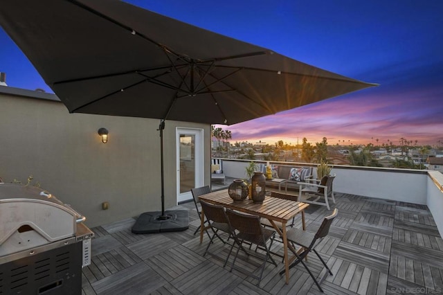 deck at dusk featuring area for grilling