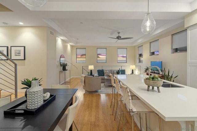 dining space with ceiling fan and light wood-type flooring