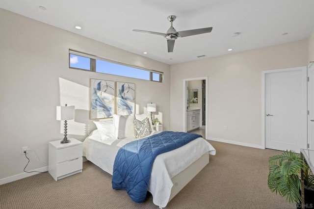 carpeted bedroom with ensuite bathroom and ceiling fan