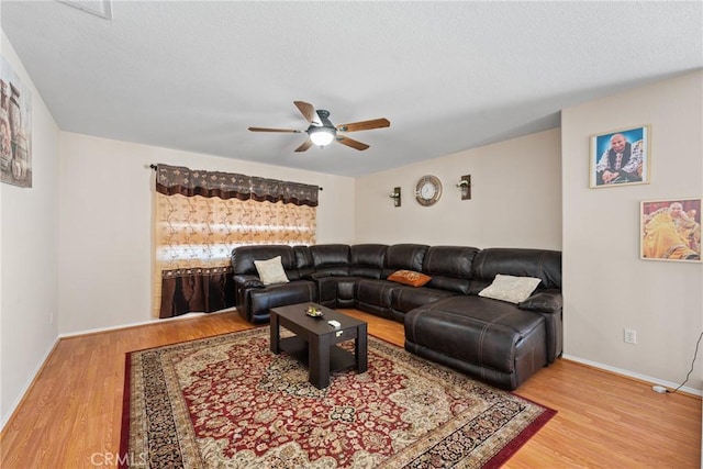 living room with hardwood / wood-style floors, a textured ceiling, and ceiling fan