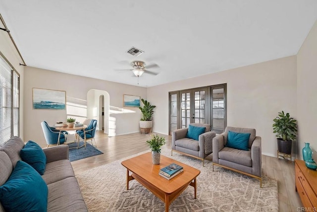 living room with ceiling fan, light wood-type flooring, and french doors