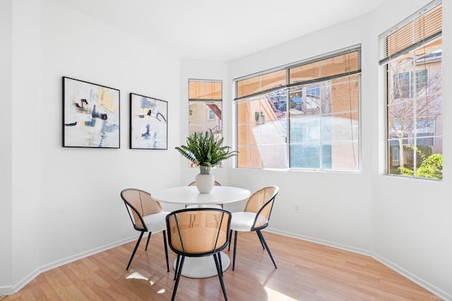 dining area featuring light wood-type flooring and baseboards