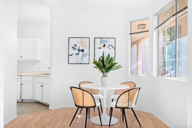 dining room featuring light wood-type flooring and baseboards