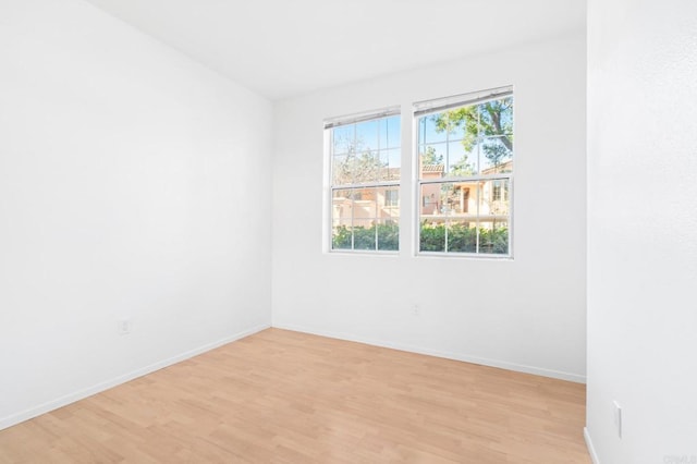 empty room with light wood finished floors and baseboards