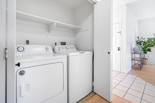 laundry room featuring baseboards, laundry area, light wood-type flooring, and washer and dryer