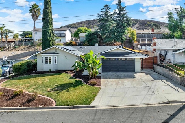 ranch-style home featuring a garage, a front lawn, and solar panels