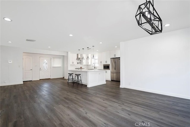 unfurnished living room featuring sink and dark hardwood / wood-style floors