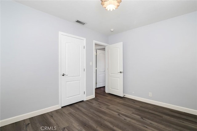 unfurnished bedroom featuring dark hardwood / wood-style flooring