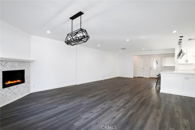 unfurnished living room featuring a fireplace and dark hardwood / wood-style floors