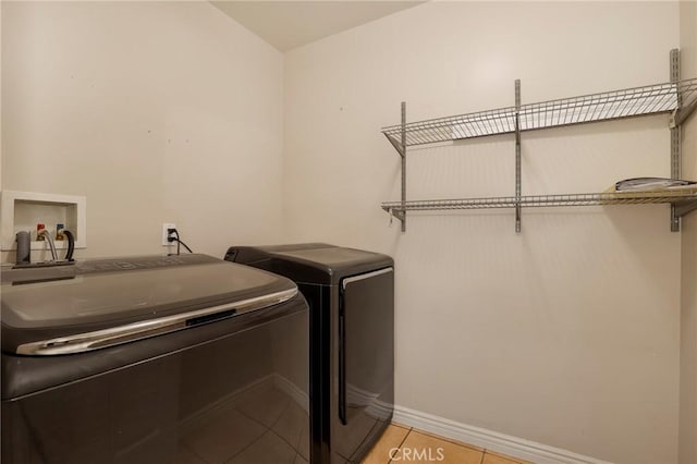 laundry area featuring light tile patterned floors and washing machine and dryer