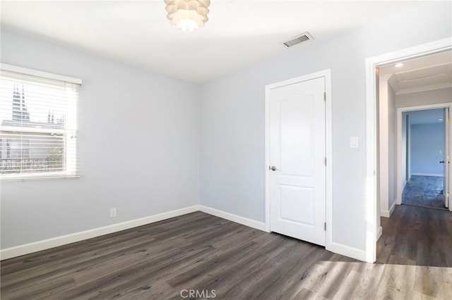 empty room with crown molding and dark hardwood / wood-style floors