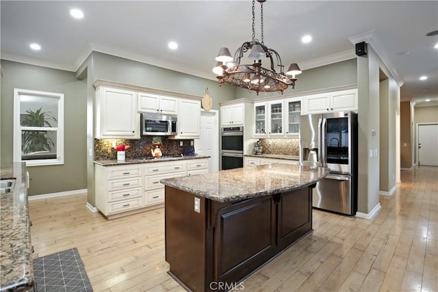 16082 Citrus Grove Ct, Riverside, CA 92504 - kitchen with backsplash, crown molding, appliances with stainless steel finishes, light stone counters, and a notable chandelier