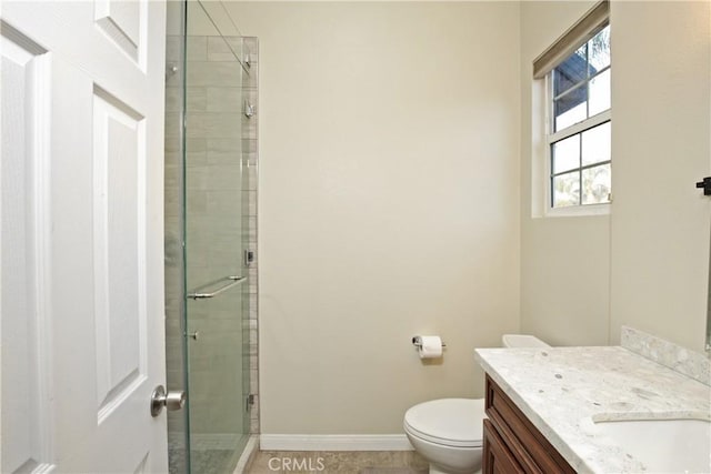 bathroom with a shower with door, vanity, and toilet