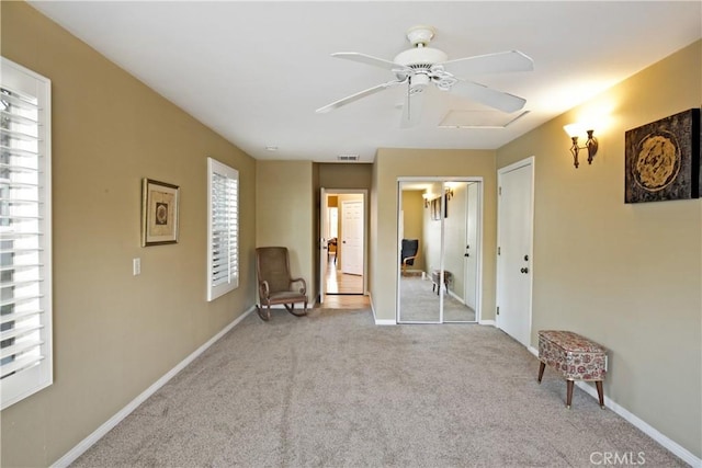 interior space featuring ceiling fan and light colored carpet