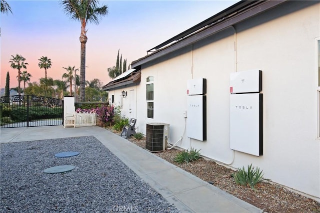 property exterior at dusk featuring cooling unit