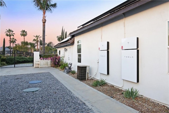 16082 Citrus Grove Ct, Riverside, CA 92504 - view of home's exterior with mail area, cooling unit, a gate, and stucco siding