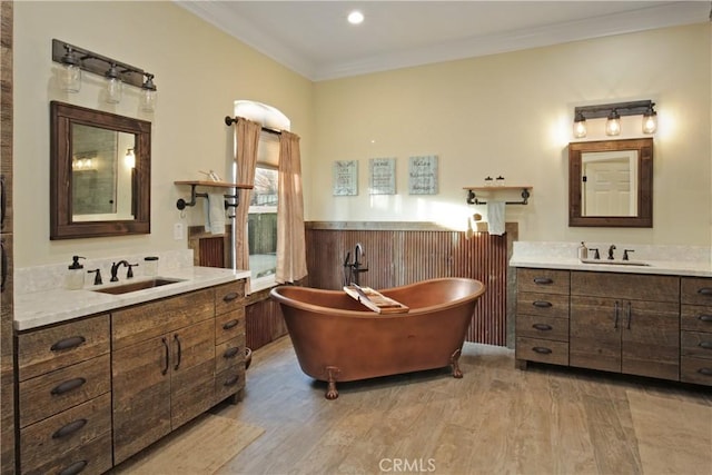 bathroom with vanity, a bath, crown molding, and wood-type flooring