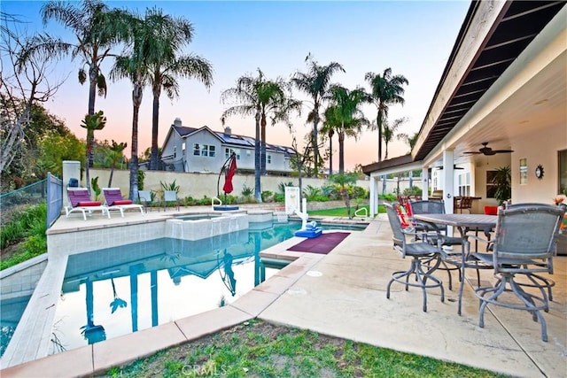 16082 Citrus Grove Ct, Riverside, CA 92504 - pool at dusk with a ceiling fan, a fenced backyard, and a patio area