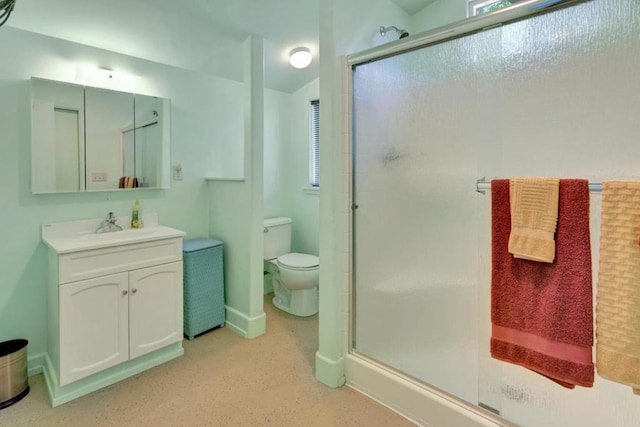 bathroom with a shower with door, vanity, and toilet